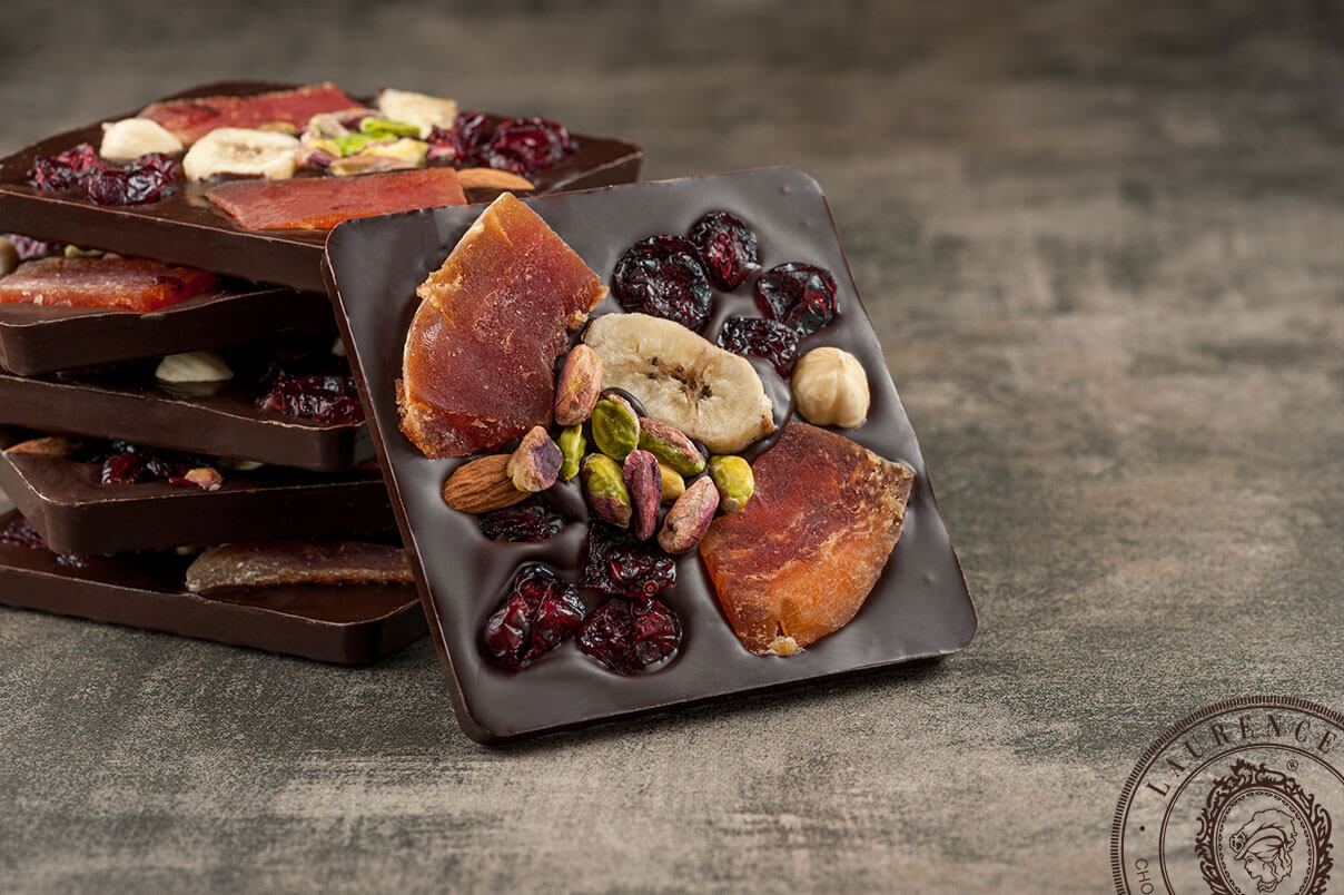 Laurence Tafelschokolade Signature Edition Zartbitterschokolade mit Früchten & Nüssen aufeinander gestapelt Laurence Tafelschokolade Signature Edition Zartbitterschokolade mit Früchten & Nüssen aufeinander gestapelt