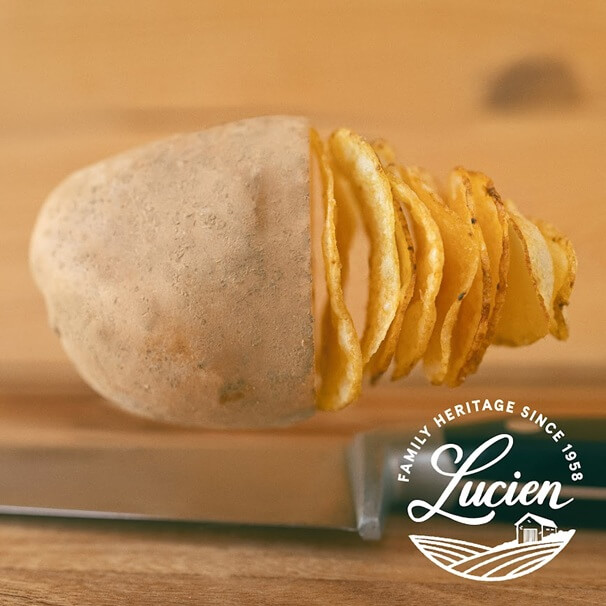 Kartoffel die in der Hälfte angeschnitten ist und zu Chipsscheiben wird Kartoffel die in der Hälfte angeschnitten ist und zu Chipsscheiben wird