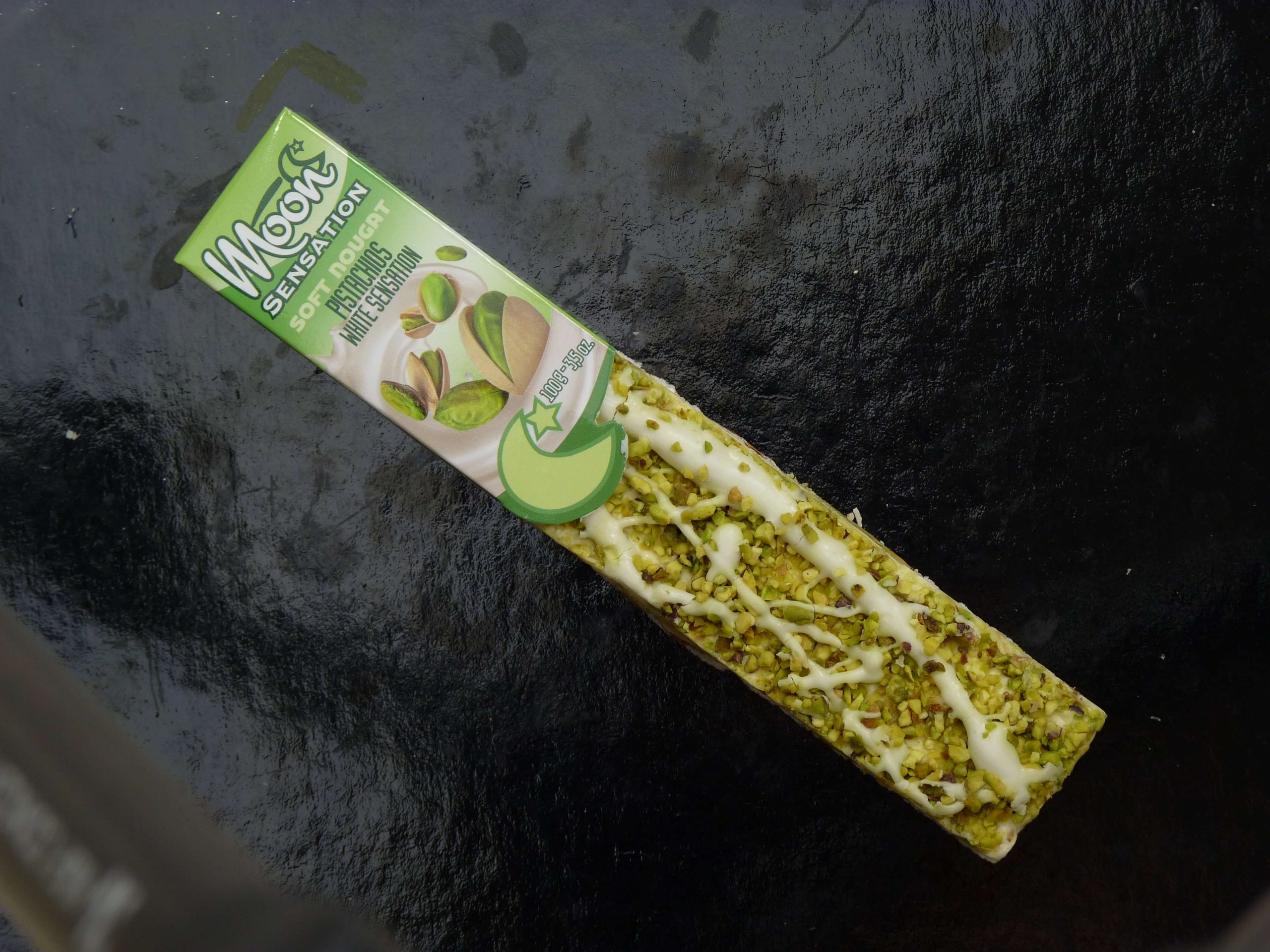 Moon Softnougat Stange Kokosnuss weiße Schokolade in der Verpackung auf einem schwarzen Hintergrund Moon Softnougat Stange Kokosnuss weiße Schokolade in der Verpackung auf einem schwarzen Hintergrund