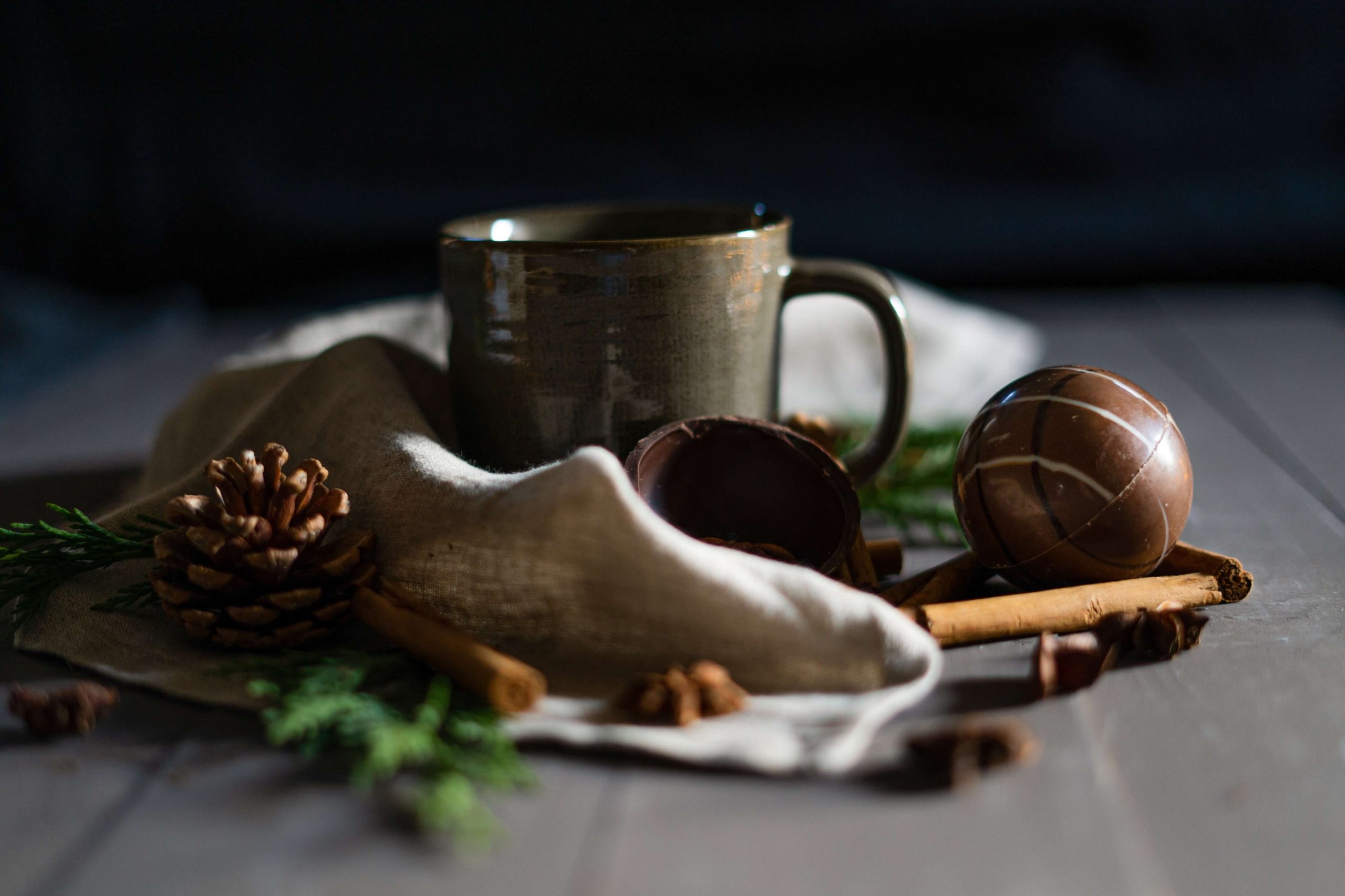 P&T Magic Hot Chocolate Ball, nett angerichtet mit Tannenzweigen, Tannenzapfen, Zimtstangen und einem Tischläufer, sowie einer Tasse P&T Magic Hot Chocolate Ball, nett angerichtet mit Tannenzweigen, Tannenzapfen, Zimtstangen und einem Tischläufer, sowie einer Tasse